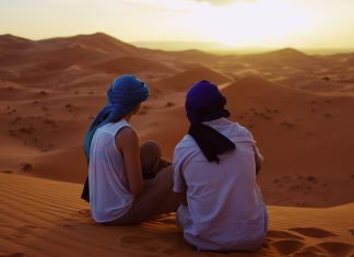 Romantic Couple Observing the Moroccan Sahara Desert Sunset
